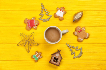 Tasty Christmas homemade cookies and cup of coffee on color wooden background