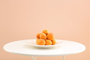 Ripe apricots on table against trendy color background