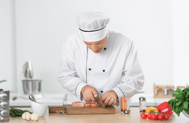 Male chef cutting meat in kitchen