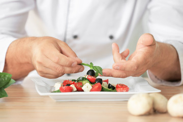 Male chef making salad in kitchen