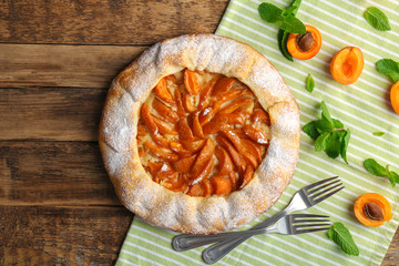Delicious apricot cake on wooden background