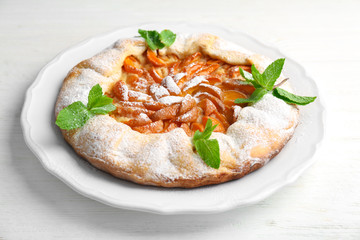 Delicious apricot cake on table