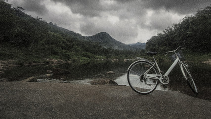Bicycle on the bridge cross over river when heavy raining day : Khiriwong Fuit Village ,Nakhon Si Thammarat Thailand (disappointed holiday concept ; vintage style)