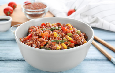 Bowl with brown rice and vegetables on table, closeup