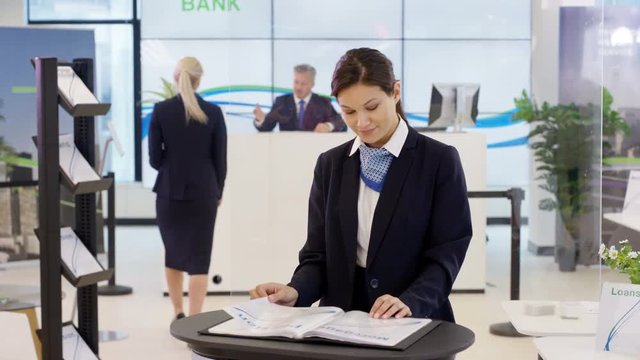 Portrait of friendly smiling financial adviser at customer help desk in bank