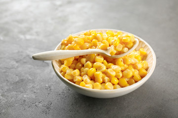 Corn kernels in bowl on grey background