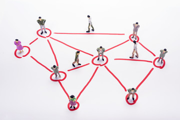 Miniature business people in conection scheme over white backdrop or background.