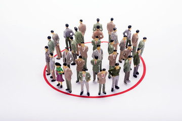 Miniature business people standing in circle over backdrop or background.