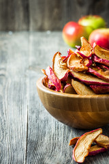 Homemade apple chips in wooden bowl. Selective focus, space for text.