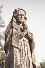 Fototapeta na wymiar Virgin Mary statue. Vintage sculpture of sad woman in grief (Religion, faith, suffering, love concept)
