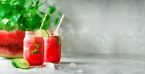 Fresh red watermelon slice and smoothie in glass jar with straw, ice, mint, lime on light background, copy space - obrazy, fototapety, plakaty