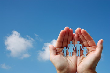 Paper family in hands on blue sky background welfare concept