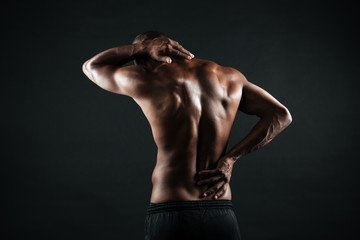 Fototapeta na wymiar Back view of young african sports man feeling pain in his back