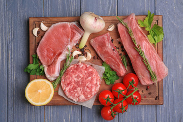 Wooden board with different types of meat on table