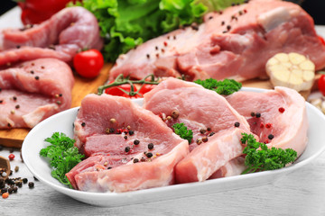 Plate with fresh raw meat on table
