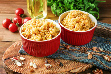 Ramekins with boiled lentils on wooden board