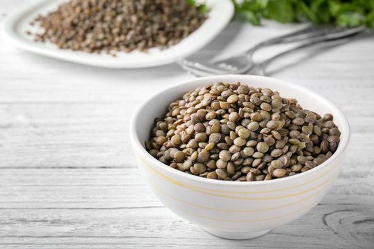 Bowl with black lentils on table