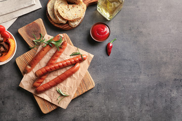 Composition with grilled sausages on kitchen table