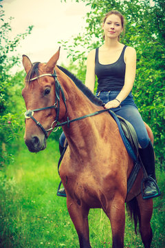 Young woman sitting on a horse