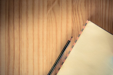 A note on a wooden floor is the background. With a wooden pencil