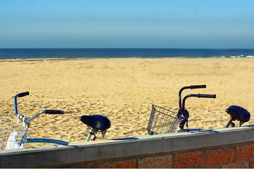 Fototapeta na wymiar Two bicycles parked on a beach ner the ocean