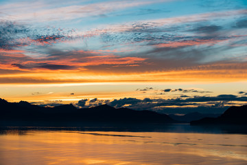Alaskan coastline sunset with mountain silhouette