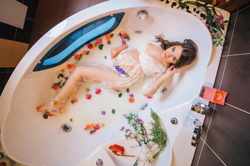 beautiful pregnant woman in a bathroom with milk and flowers. 