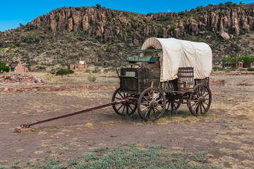 Side view of canvas covered wagon with green buck board