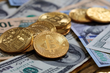 Bitcoins stack on dollar banknotes background