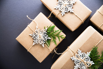 Christmas handmade gift boxes decorated with craft paper, branch and snowflake on dark background top view. Merry christmas greeting card, frame. Winter xmas holiday theme. Happy New Year. Flat lay