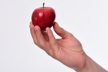 Male hand holds red apple. Apple in bright juicy color