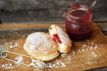 Delicious fresh donuts with cherry jam on the table
