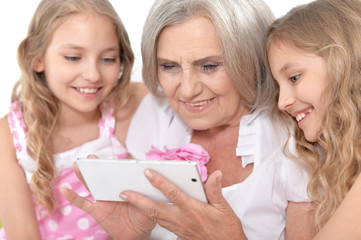 granny with granddaughters using smartphone