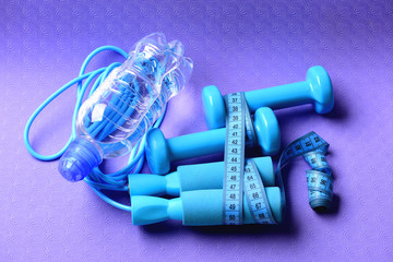 Dumbbells, water bottle and jump rope in cyan color