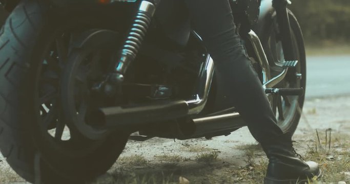 Female biker sitting on her motorcycle on a forest road. 4K UHD 60 FPS