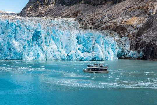 Close up view of tourist boat next to glacier face