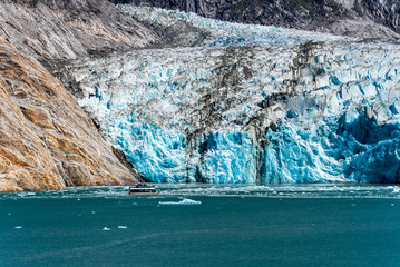 View of glacier face with blue snow and tourist boat