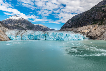 Fototapeta na wymiar Long distance view of an Alaskan glacier with aqua icy waters
