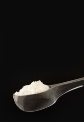 Raw rice in wooden spoon - Oryza sativa