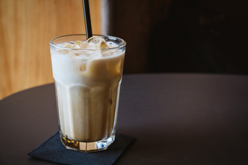 Glass of iced coffee or latte on a wooden table