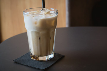 Glass of iced coffee or latte on a wooden table