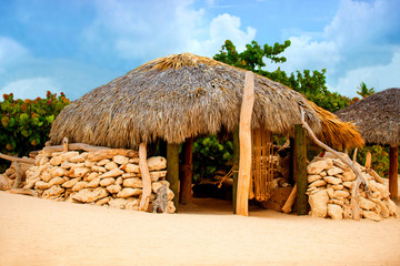 A hut made of stone and thatched roof.