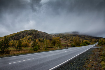 Fototapeta premium Road in the mountains with low clouds