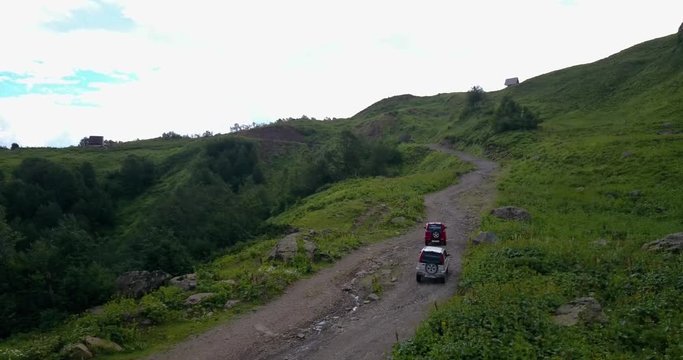 Aerial view. Two off-road cars driving on a mountain road