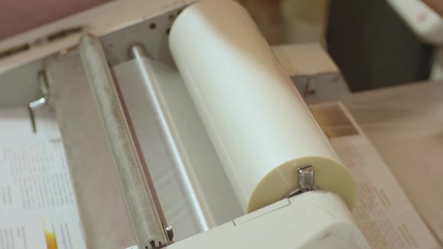 Сaucasian male working with roll laminator