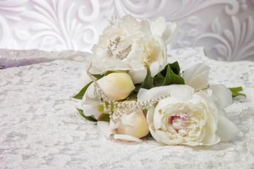 wedding bouquet of white peonies on the wedding dress with jewelry