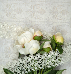 a bouquet of white peonies on the paper retro background with lace