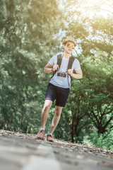 Young man tourists shooting vintage camera and backpack, shooting style, travel style in the forest.