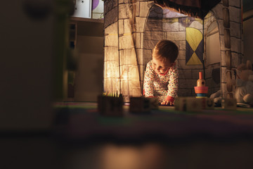 Little boy playing into castle toy at home.