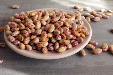 Dry White Beans on a plate on wooden background.
